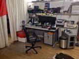 a room with a lot of clutter and a desk with a laptop on it