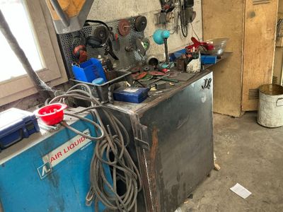 une photo d'un établi dans un garage avec de nombreux outils