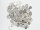 a pile of silver and silver coins on a white surface