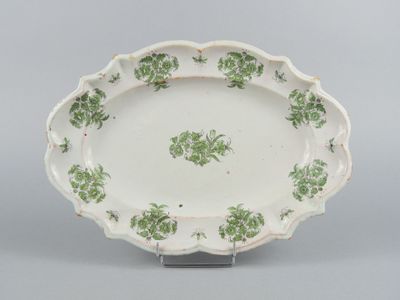 an oval platter with green and white flowers on it