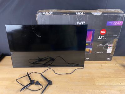 La télévision est posée sur la table, à côté du carton.