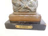 une statue représentant un homme assis sur un livre