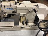 une machine à coudre blanche posée sur une table dans une pièce