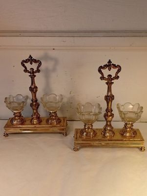 deux bougeoirs en or posés sur une table blanche