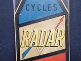 une enseigne Radiar vintage accrochée à un mur bleu dans une pièce