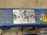 a close up of a blue machine with a warning sign on it