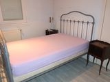 a bed with a pink sheet on it in a room