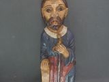 une statue en bois représentant un homme coiffé d'un chapeau