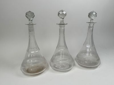 three clear glass decanters sitting next to each other on a white surface