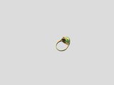 a close up of a gold ring with a green stone in it