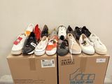 many pairs of shoes sitting on top of a cardboard box