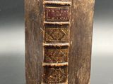 an old book sitting on top of a table next to a black background