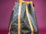 a louis vuitton handbag on a pink background