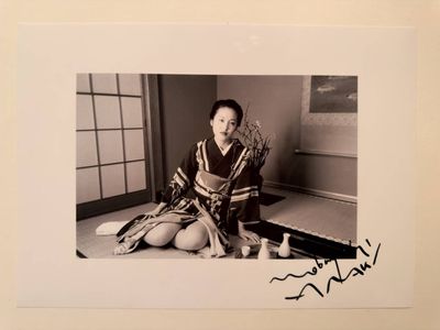 black and white photograph of a woman sitting on the floor reading a book