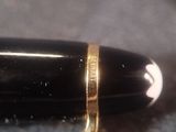 a close up of a fountain pen with a gold band on it