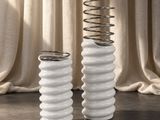 deux vases blancs contenant des branches de printemps, posés sur une table