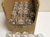 a cardboard box filled with empty glass jars on a table