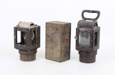 two old fashioned lanterns sitting next to each other on a white surface