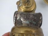 a person holding a small brass bell in their hand