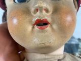 a close up of a doll with a red hat on