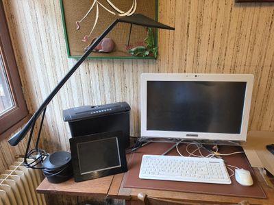 a desk with a computer, keyboard, mouse, and speakers on it