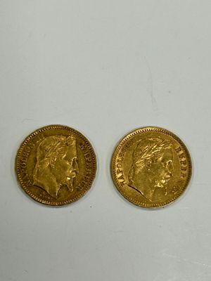 two pieces of gold coins sitting on top of a white surface