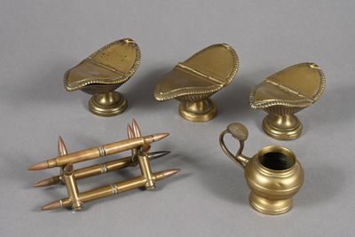 three antique brass objects on a gray surface
