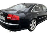 the rear end of a black car with a license plate on it
