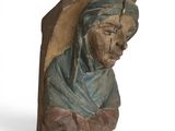 une image représentant une sculpture en bois d'une femme portant un foulard bleu