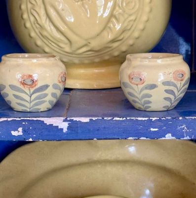 deux bols et un vase posés sur une étagère dans un meuble bleu