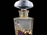 an image of a glass bottle with a statue on top of it
