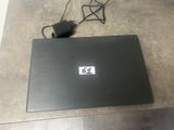 a laptop that is sitting on the floor with a charger attached to it