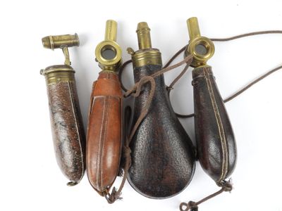 trois combinés téléphoniques anciens en laiton et cuir sont alignés sur une surface blanche