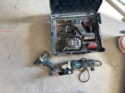 une boîte à outils contenant des outils, posée sur le sol