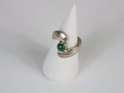 a close up of a ring with a green stone on it