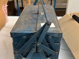 une boîte à outils bleue posée sur une table dans un atelier