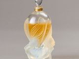 a small glass bottle with a bird inside of it