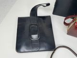 a black purse and a red purse sitting on a table