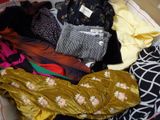 une pile de vêtements posée sur un lit