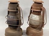 pair of antique keroseane lamps on stands on a white background