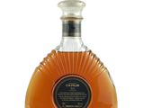 une photo d'une bouteille de brandy posée sur une surface blanche