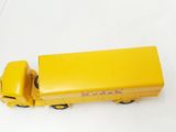 a yellow toy truck that is sitting on a white surface