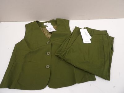green jacket and pants on a white table with tags on them