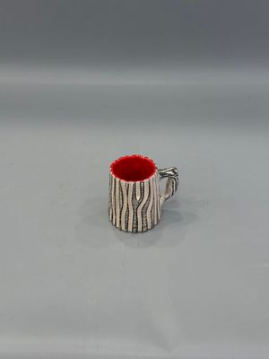 un gobelet rouge posé sur une table blanche