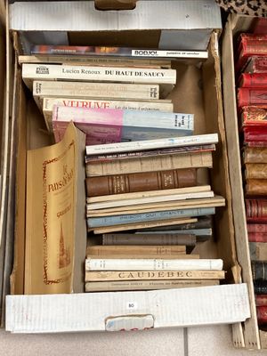 une boîte pleine de livres posée sur le sol