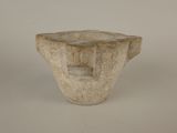 a small stone vase with a square hole in the middle