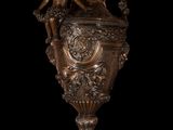 statue of a woman sitting on a vase on a black background