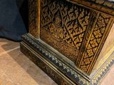 a small wooden box on the floor with a black background