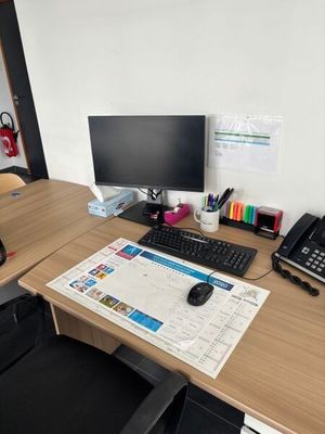 un bureau sur lequel se trouvent un ordinateur, un téléphone et d'autres fournitures de bureau