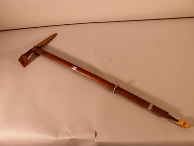 un bâton en bois muni d'un manche en bois, posé sur une surface blanche